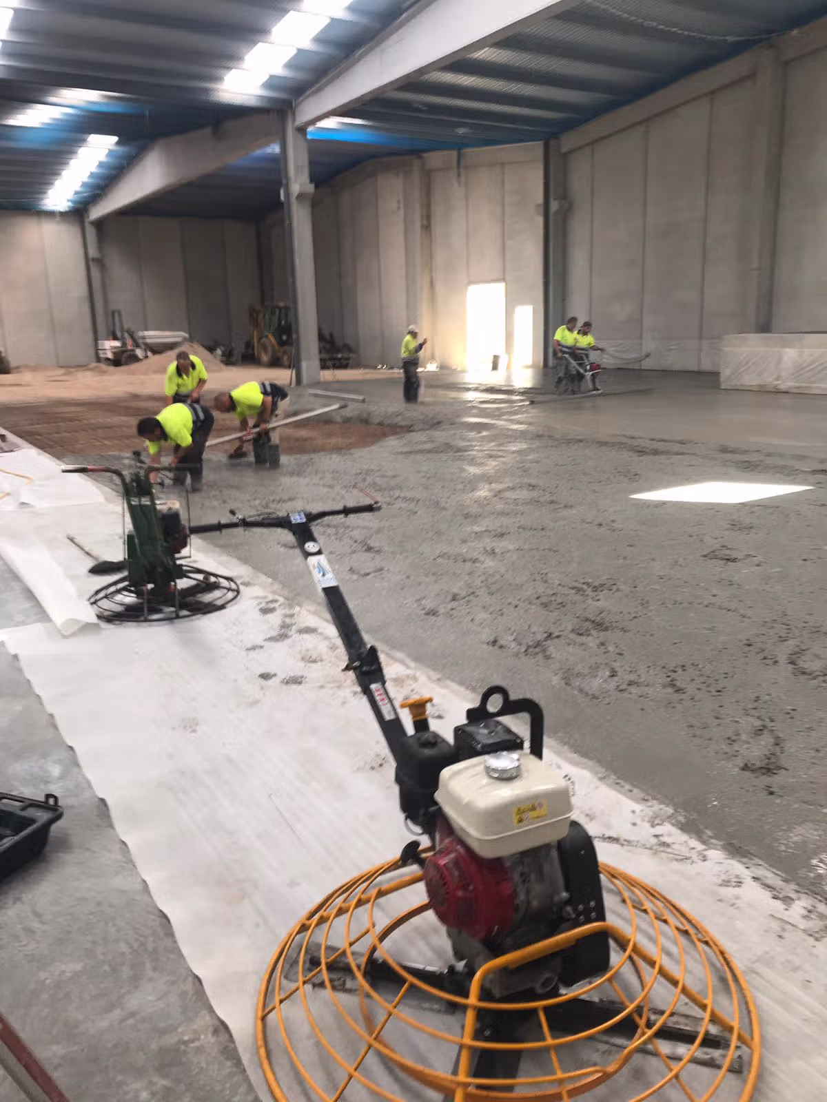 Trabajos de nivelación y acabado del pavimento de hormigón en la nave