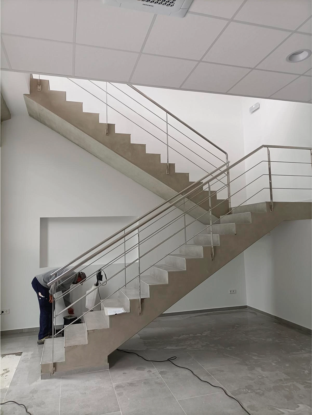 Escalera interior de hormigón con barandilla metálica en GP Recambios