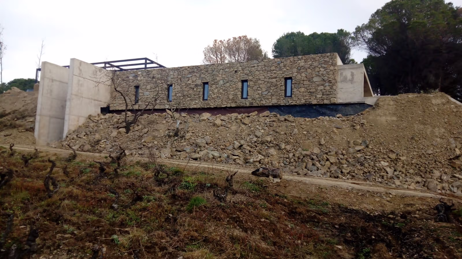 Fachada de piedra y hormigón de la bodega Celler RIM en Rabós d’Empordà