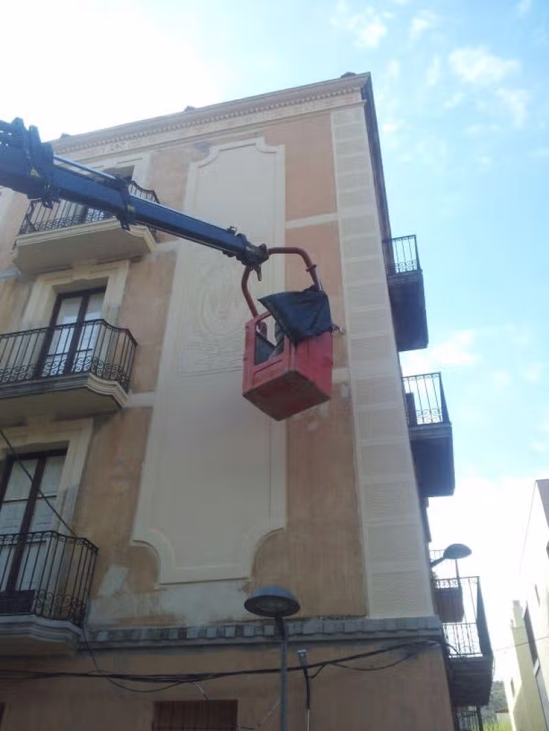 Trabajos de recuperación de molduras y motivos ornamentales en una fachada de Portbou