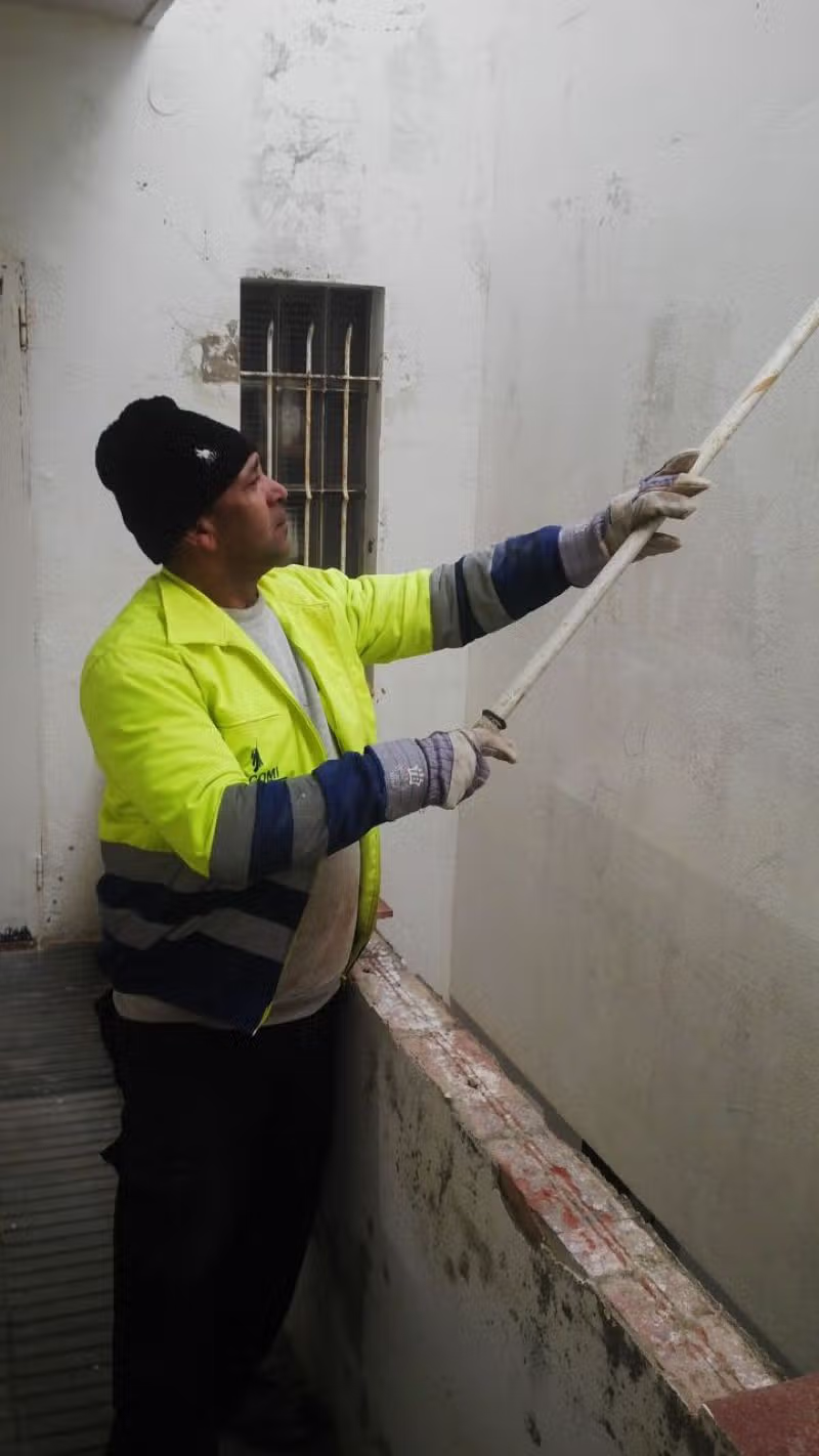 Aplicación de revestimiento reforzado en un patio del edificio de Cala Rovellada
