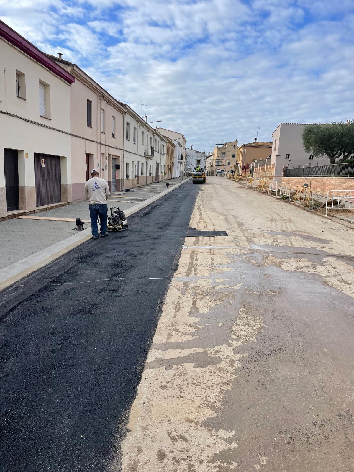 Operario de SECOMI compactando junto al aglomerado nuevo extendido en el carrer Dr. Fleming