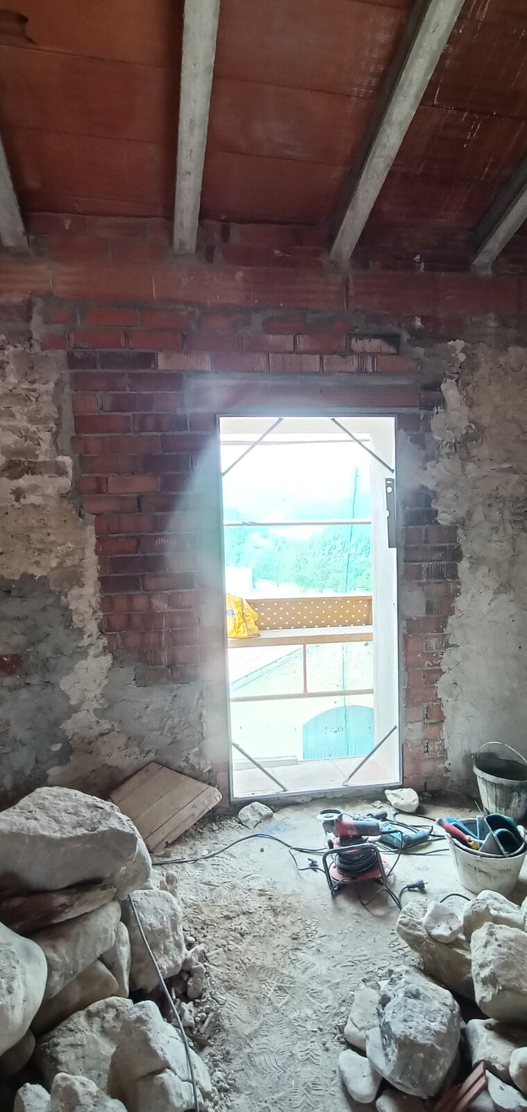 Trabajos de derribo interior con los muros de piedra originales y una ventana antigua a la vista