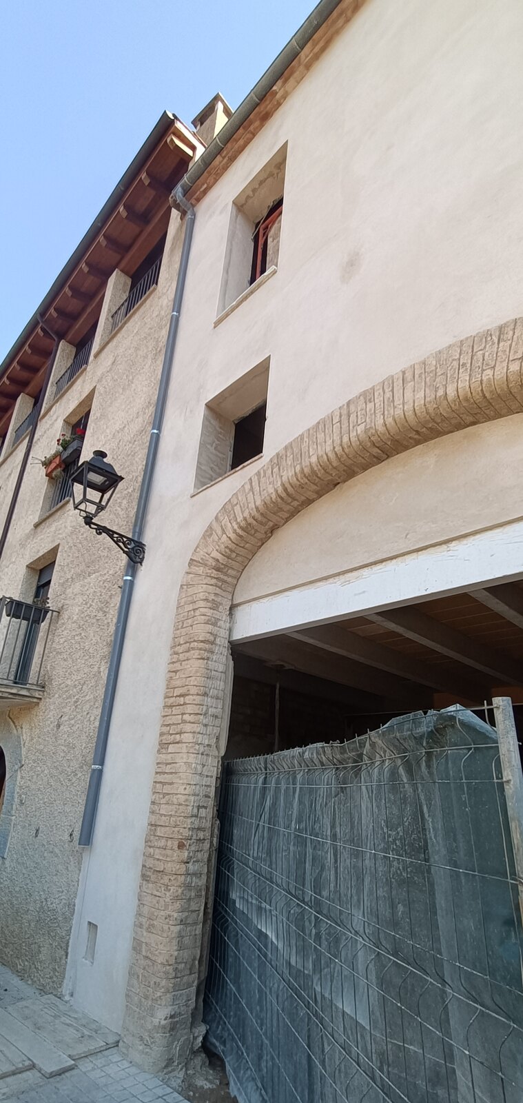 Fachada de la casa entre medianeras con arco de ladrillo en el centro de Mieres, antes de la reforma